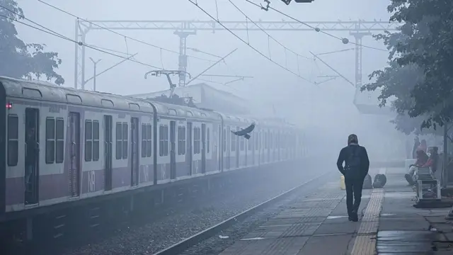  ၂၀၂၅ ခုနှစ် ဒီဇင်ဘာလ ၂၀ ရက်နေ့က အိန္ဒိယနိုင်ငံ နယူးဒေလီမြို့ တီလက်ခ် မာဂ် ဘူတာရုံမှာ အေးခဲတဲ့ ဆောင်းတွင်းမနက်ခင်း မြူတွေအကြား ခရီးသည်တင်ရထားတစ်စင်း ဖြတ်မောင်းသွားစဉ် လူတစ်ဦးကို နောက်ကနေ မြင်ရပုံ