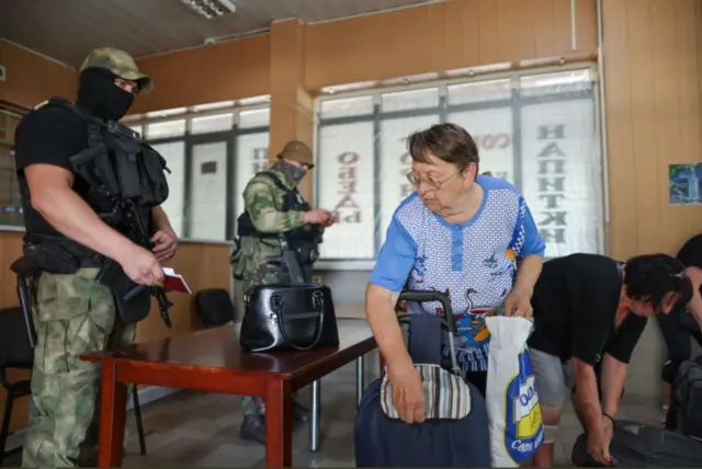 Херсондогу автовокзалда жүргүнчүнүн буюм-тайымын текшерип жаткан учур. 2022-жыл, июль айы
