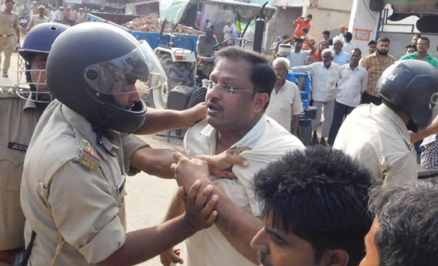 तस्वीर में पुलिस के साथ शिकायतकर्ता मनोज टिबड़ेवाल आकाश दिख रहे हैं. यह तस्वीर साल 2019 की है, जब उनके घर पर बुलडोजर चलाया गया था. 