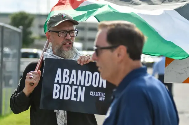 Protesta contra la política de Biden ante la guerra en Gaza. Un hombre porta un cartel que dice "Abandona a Biden".