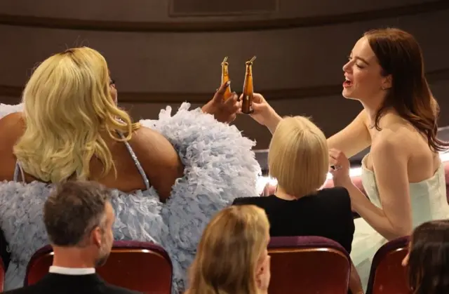 En iyi yardımcı aktris ve en iyi aktris ödüllerini alan Da’Vine Joy Randolph ve Emma Stone, ödül töreninde kadehlerini tokuştururken