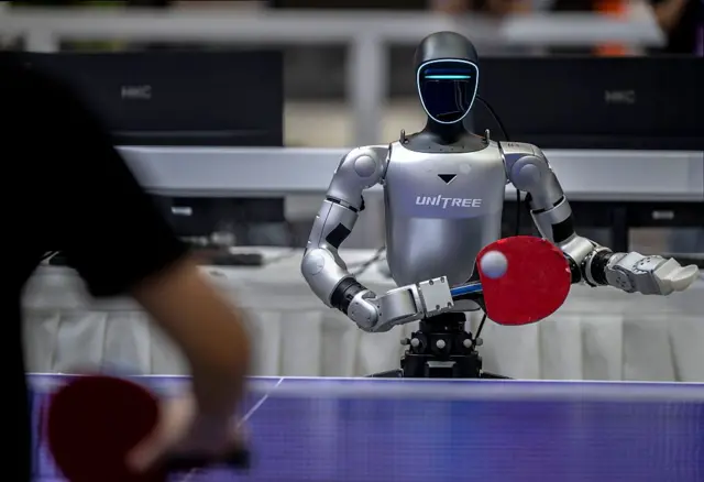 Un robot androide de Unitree jugando ping-pong.