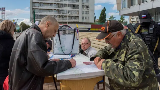 在烏克蘭東部盧甘斯克的一個戶外投票站，人們面對面填寫選票