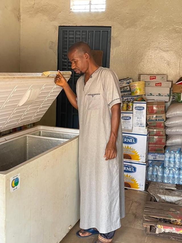 Mamadou Bah vérifie l'état de ses produits surgelés stockés dans le congélateur.