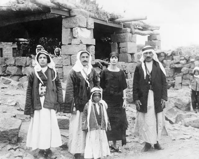 السيدة في الصورة هي زوجة ويليام سيبروك، وهو مراسل صحفي أمريكي كتب سلسلة مقالات عن الثورة ضد الفرنسيين في سوريا، وعن يمينها علي بك الأطرش، وعن يسارها مصطفى بك الأطرش، وهما شقيقا سلطان باشا، قائد الثورة ضد الفرنسيين