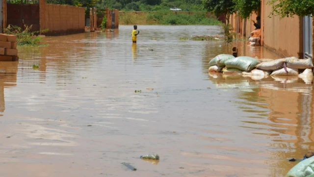 A child wades through water on a flooded street in the Kirkissoye quarter in Niamey on September 3, 2019. - Several quarters of the Nigerian capital are devastated by the floods caused by the exceptional high tide of the Niger River that affect the entire country since June.