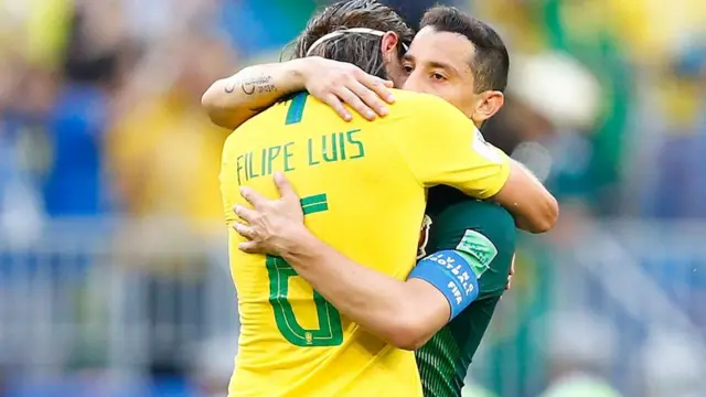 Pemain bertahan Brasil Filipe Luis memeluk gelandang Meksiko Andres Guardado setelah pluit panjang.