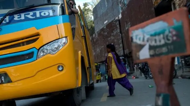 Seorang sukarelawan bersiap-siap untuk memeriksa sebuah bus yang akan meninggalkan lembah Kathmandu, kalau-kalau ada korban perdagangan manusia.