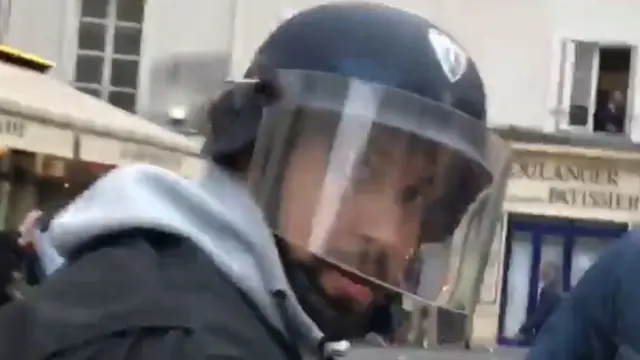 رجل يرتدي زي الشرطة يقال إنه بينالا مساعد ماكرون