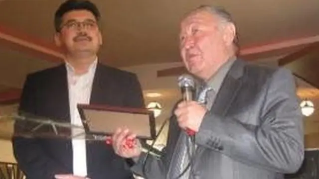 Кыргыз эл жазуучусу Казат Акматов жазуучу Арслан Капай уулу Койчиевге "Арча" сыйлыгын тапшырууда. 23-март 2012-жыл, Бишкек