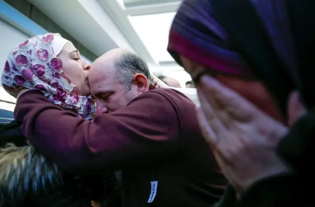Pengungsi Suriah Baraa Haj Khalaf mencium ayahnya, Khaled setibanya di O'Hare International Airport di Chicago.