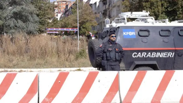 Vojnik Kfora ispred oklopnih vozila na mostu u Mitrovici na Kosovu