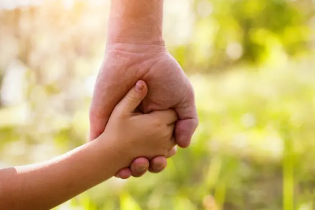 Padre e hijo tomados de la mano