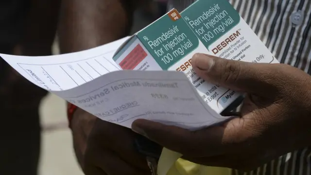 Un homme tient des boîtes de Remdesivir, un médicament antiviral utilisé pour traiter les symptômes du coroanavirus Covid-19,
