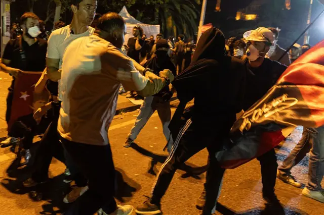 Bir sivil polis, bir eylemciyi gözaltına almaya çalışıyor.