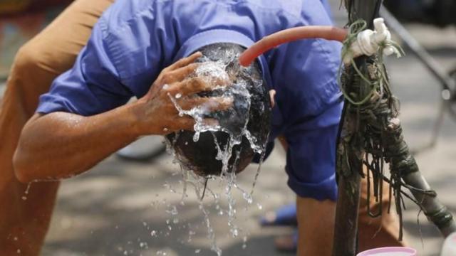 তীব্র গরমে অতিষ্ঠ জনজীবন, স্বস্তির খোঁজে সড়কে মাথা ধুয়ে নিচ্ছেন একজন পথচারী