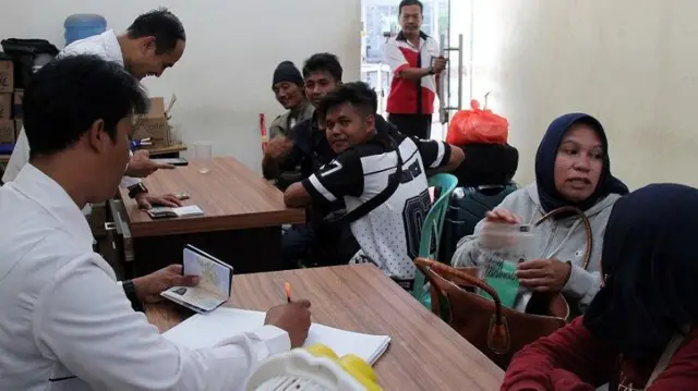 petugas mendata sejumlah pekerja migran yang mudik dari Malaysia di Pos Pelayanan Perlindungan Pekerja Migran Indonesia (P4MI), Terminal Penumpang Pelabuhan Pelindo Dumai, Riau, Rabu (3/4/2024).