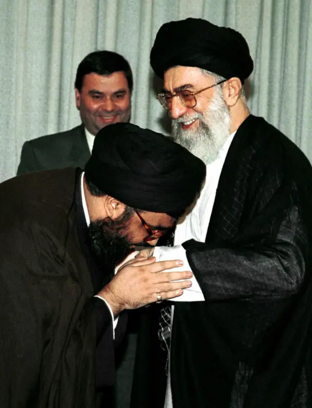 Хасан Насралла Ирандын жогорку лидери Аятолла Али Хаменеинин колун өбүүдө, Тегеран, 04-июль 2000-жыл