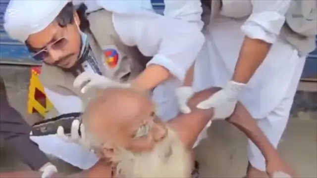 একজন বৃদ্ধ লোককে জোর করে মাথা কামিয়ে দিচ্ছে একজন লোক