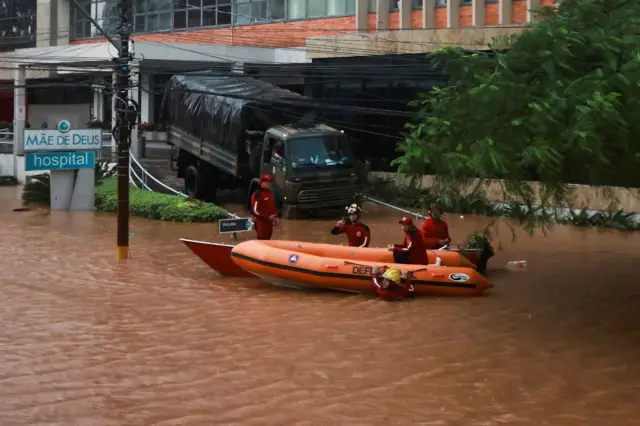 Boteinscription zebetfrente a uma rua alagada onde há um hospital