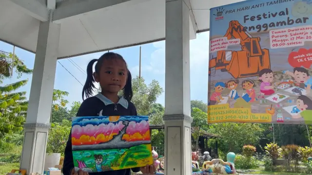 Tisya menunjukkan gambar tanggul lumpur dengan kreasi warna dan imajinasinya mengenai kampung halaman