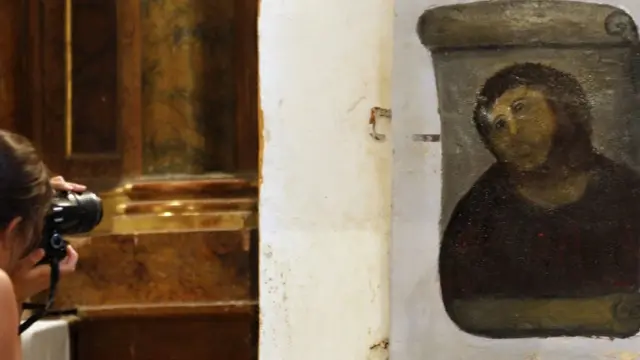 Turis mengambil foto Ecce Homo setelah "direstorasi"