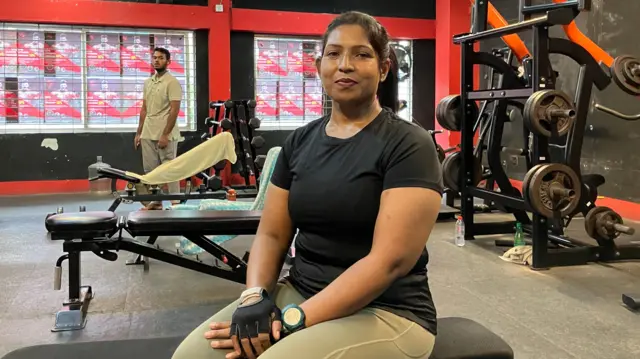 ఢాకాలో వెయిట్‌లిఫ్టింగ్ జిమ్‌లో ఒక బెంచ్‌పై కూర్చున్న ఫర్జానా లియో