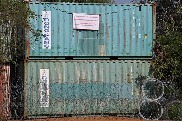 Shipping containers and barbed wire, installed by Thai forces, block a street in Chouk Chey village in Banteay Meanchey province on February 5, 2026. A sign hanging from a rusty ice-green shipping container installed by Thai forces on what they say is the border with Cambodia proclaims: "Cambodian citizens are strictly prohibited from entering this area." (Photo by TANG CHHIN Sothy / AFP via Getty Images) / To go with 'THAILAND-CAMBODIA-CONFLICT-BORDER,REPORTAGE' by Suy SE and Montira RUNGJIRAJITTRANON