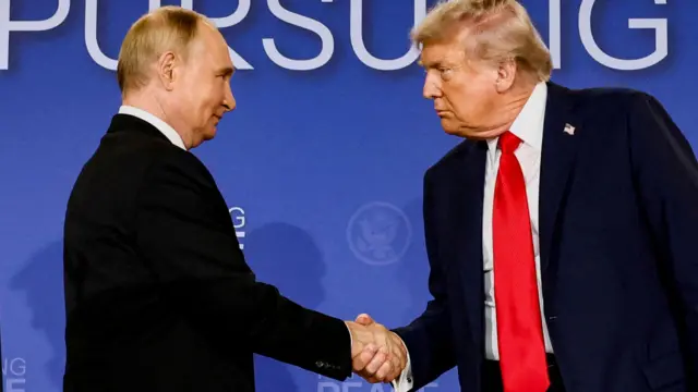 Владимир Путин и Дональд Трамп жмут друг другу руки во время встречи в Анкоридже