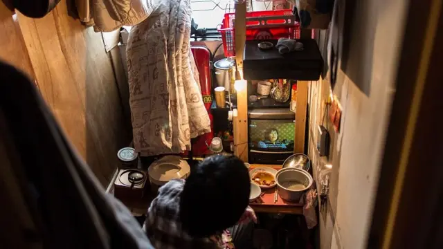 一名劏房居民正在房間裏看電視(18/4/2016)