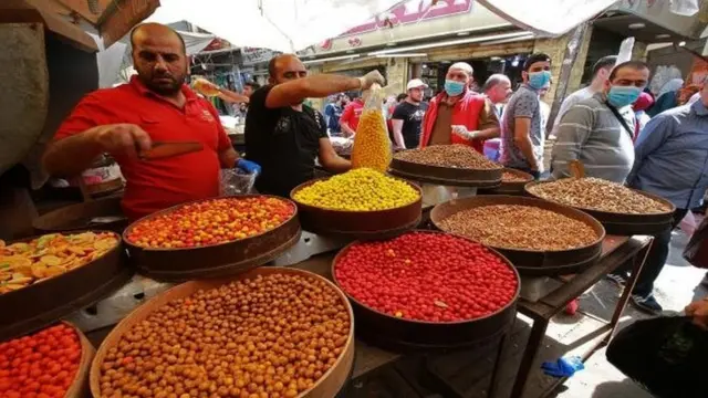 أشخاص يرتدون كمامات في أحد الأسواق