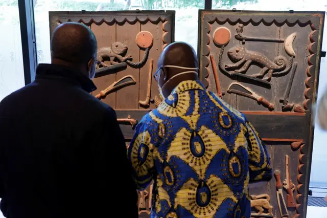 Visitors look at doors of King Glele's Palace (1880-1889).
