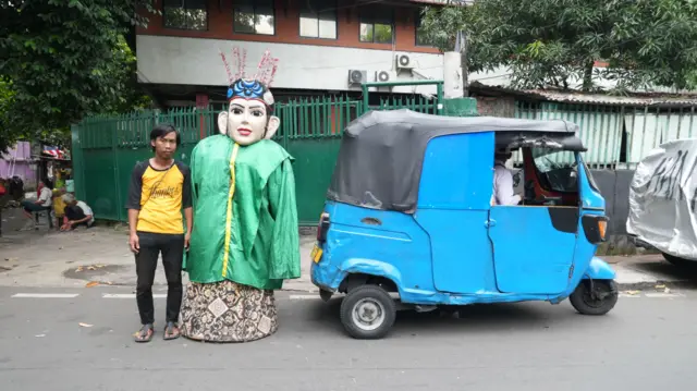 Ahmad Muchsin berdiri di sebelah ondel-ondel yang digunakan untuk mengamen di kawasan Senen, Jakarta Pusat, pada Kamis (28/8)