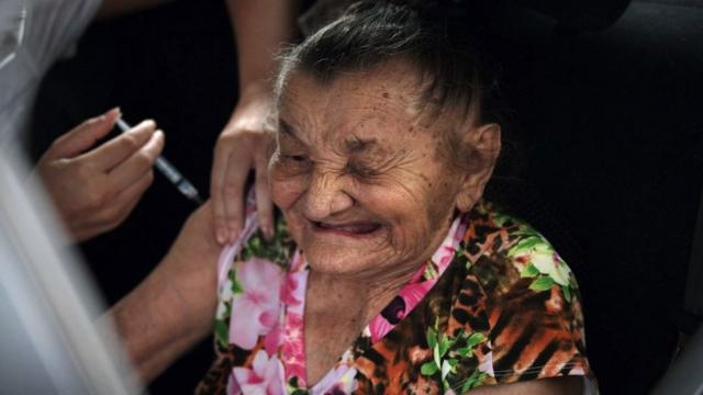 A Brazilian elderly woman receives a dose of the Coronavac vaccine at a drive through vaccination center at the Sambodrome Rio Carnival venue, in Rio de Janeiro, Brazil, on February 6, 2021.