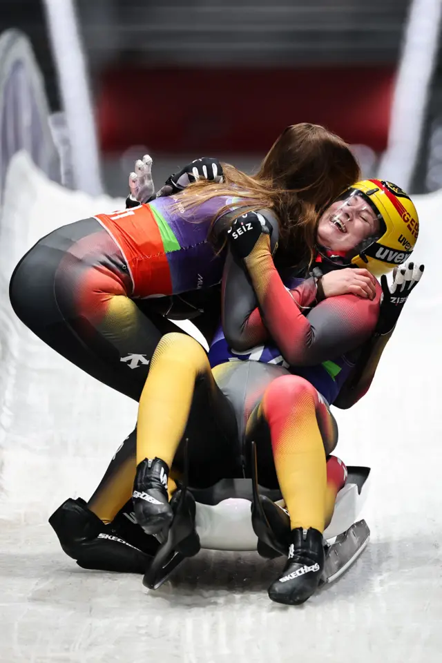 Немецкие спортсменки Даяна Айтбергер и Магдалена Матшина радуются победе в женских двойках в командной эстафете по санному спорту