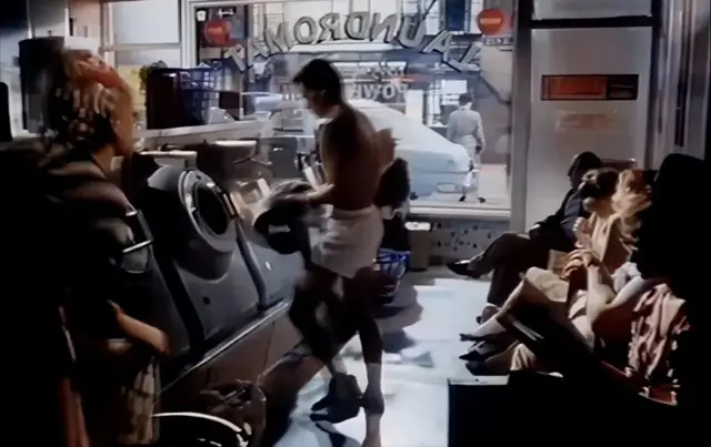 여성들이 지켜보는 가운데 사각 속옷만 입고 세탁기에 옷을 넣는 남성