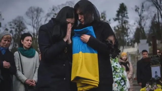 mulheres chorando com bandeira da Ucrânia