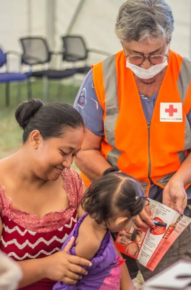 Una mujer y una niña reciben información sobre vacunación