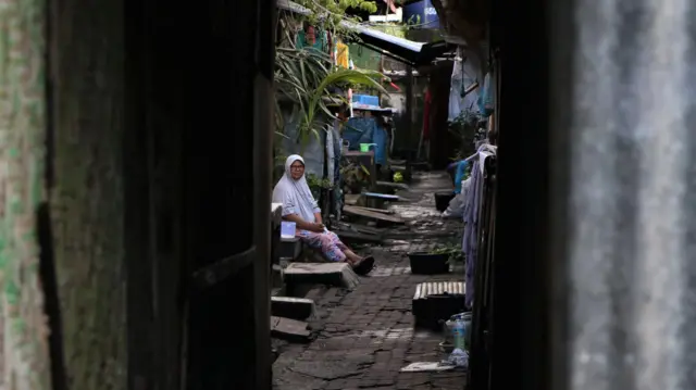 Seorang ibu duduk di lorong dekat dapur umum di Wisma Transito, Mataram, NTB.