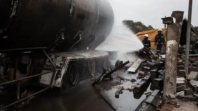 Fireman dey spray water on top one tanker for di site where di explosion happen inside Accra, October 8, 2017 a day after a gas tanker catch fire on October 7
