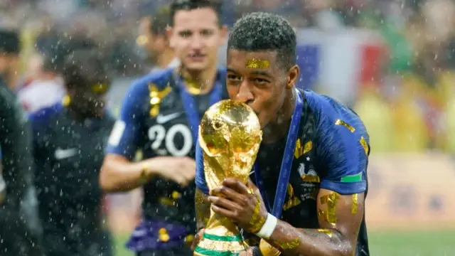 Le Français Presnel Kimpembe célèbre la victoire, trophée en main, après la victoire de la France