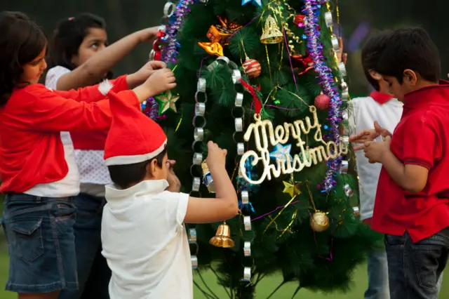 Children stand near Christmas tree