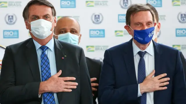 O Presidente do Brasil Jair Bolsonaro e o Prefeito do Rio de Janeiro Marcelo Crivella durante execução do hino nacional durante a inauguração da Escola Civico-Militar General Abreu em 14 de agosto de 2020 no Rio de Janeiro, Brasil