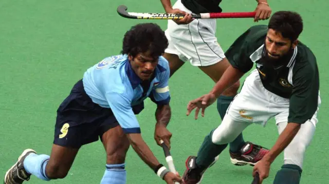 (নীল জার্সিতে) ধনরাজ পিল্লাই ও পাকিস্তানের হকি খেলোয়াড় আকিল খান