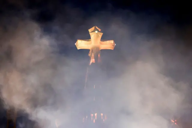 Крест на башне Христа в дыму от фейерверка