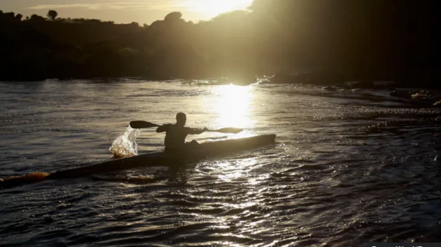 Wani mutum na tuƙa kwale-kwale a ruwa