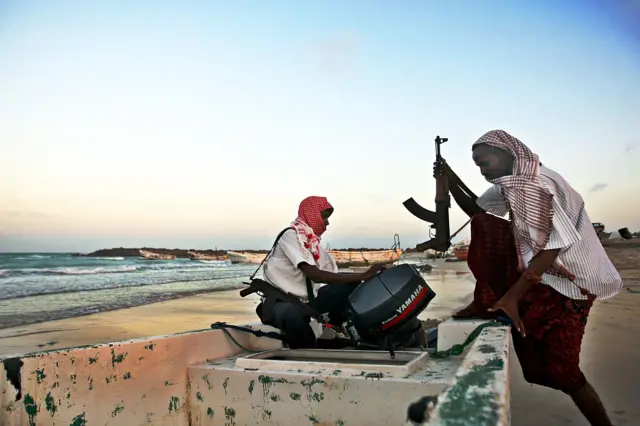 Foto yang diambil pada 4 Januari 2010 memperlihatkan para perompak Somalia bersenjata sedang melakukan persiapan di sebuah perahu kecil di Hobyo, Somalia timur laut, menjelang serangan baru terhadap kapal-kapal yang berlayar di Teluk Aden.