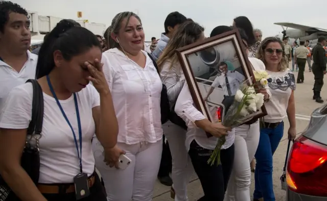 Familiares y amigos del piloto del avión de Lamia accidentado, Miguel Quiroga, cargan una fotografía suya durante su funeral.