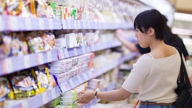 Woman buying nattō in a supermarket