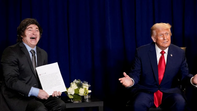 Javier Milei e Donald Trump sentados um ao lado do outro e rindo